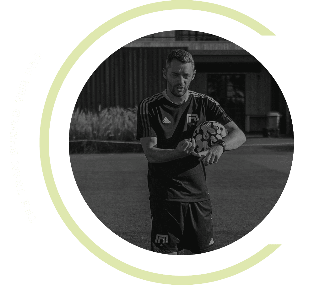 A black and white photo of a man holding a soccer ball.